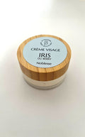 Crème Visage Iris du Berry, Noblesse - pot en verre à couvercle bambou entouré de fleurs d'iris violettes